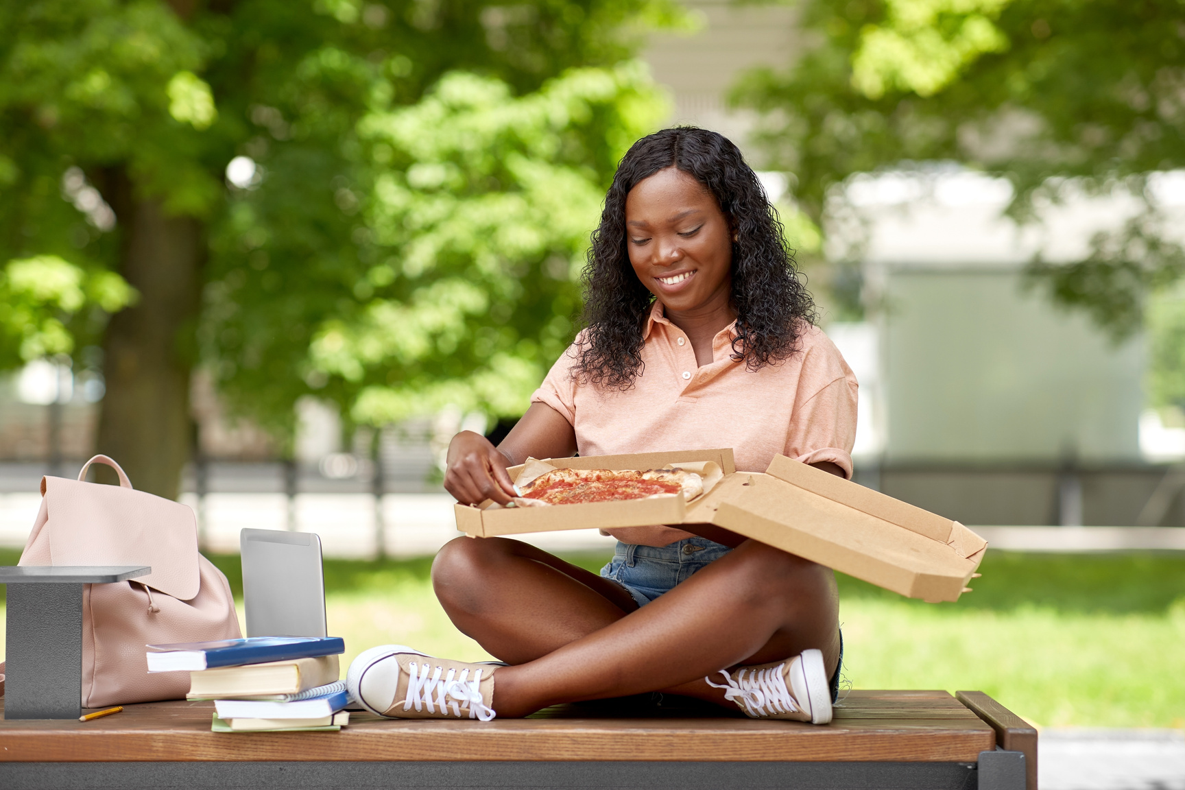African Student Girl Eating Takeaway Pizza in City